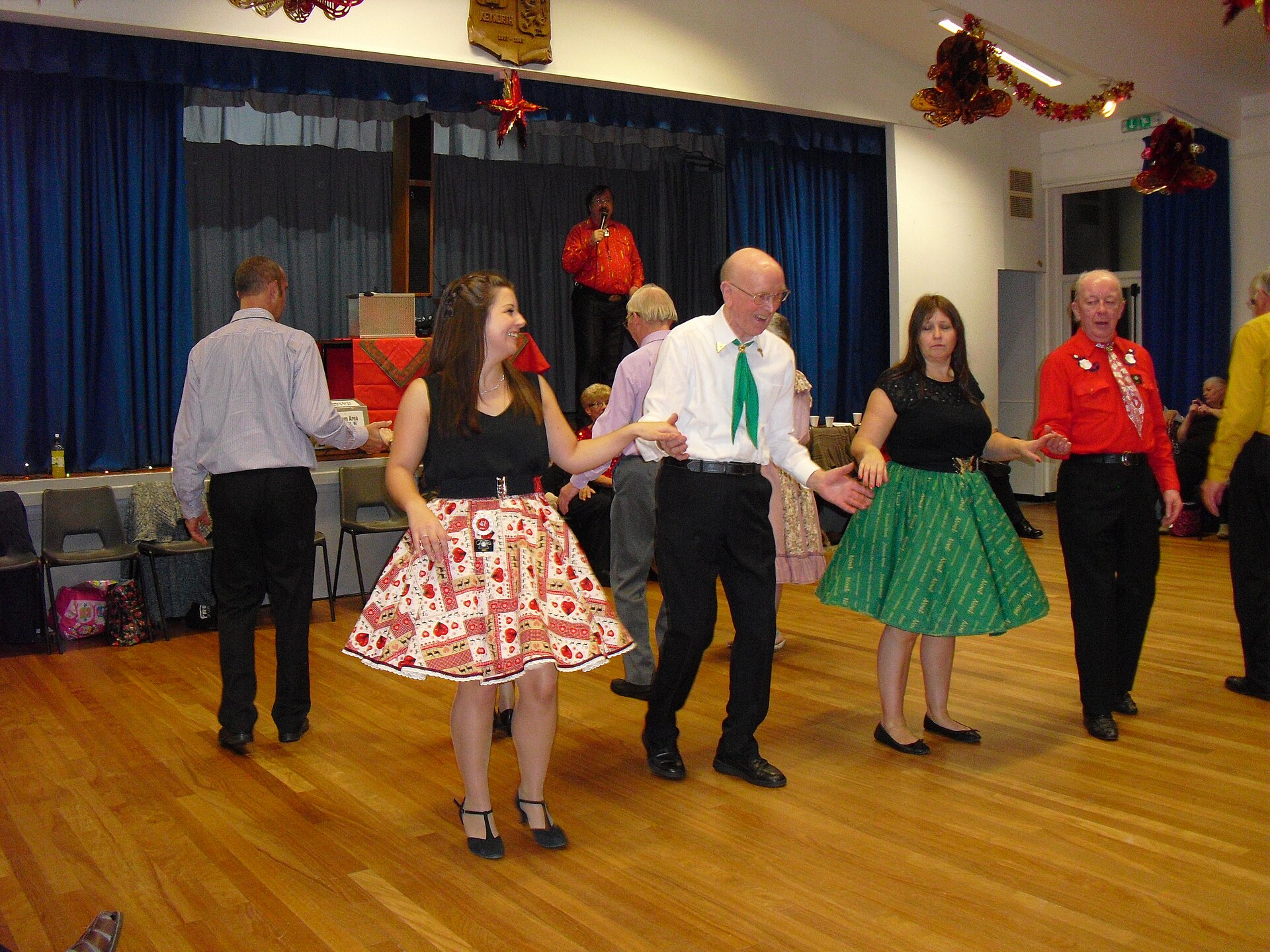 Square dancers following a caller in a community hall