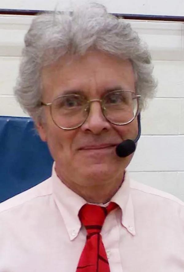 Chris Pinkham wearing glasses and a headset microphone